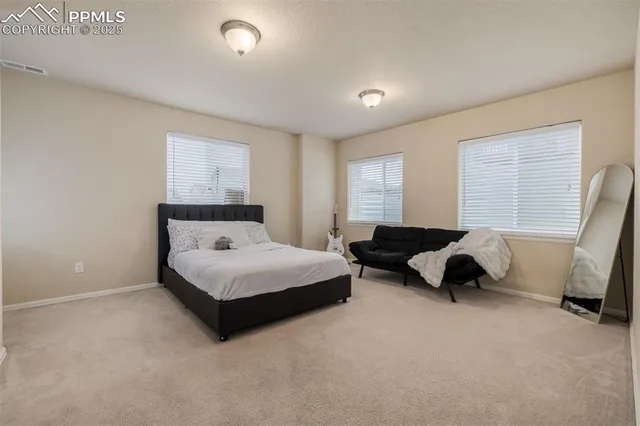 a bedroom with a bed a couch and a window