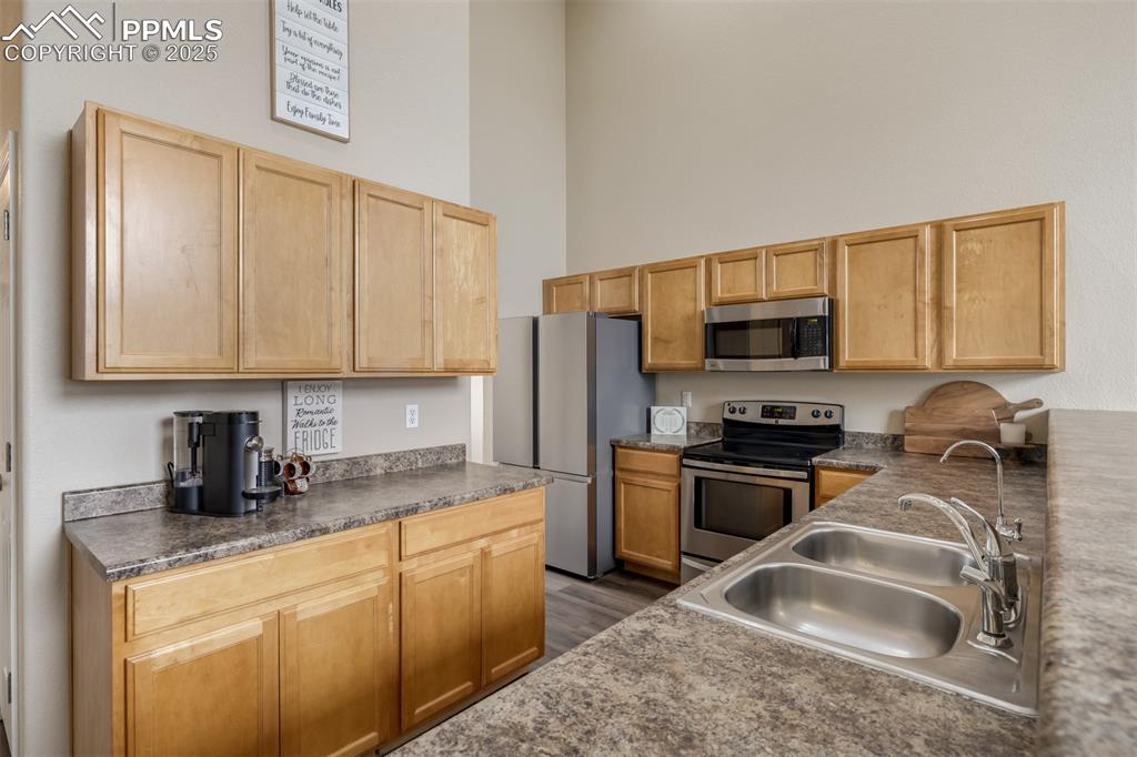 4966 Spokane Way Colorado Springs, CO 80911 - Photo 10 of 35 a kitchen with stainless steel appliances granite countertop a sink stove and refrigerator