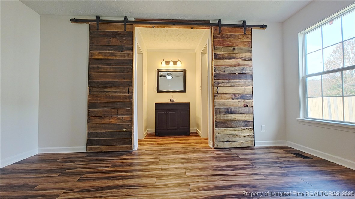 704 South Bethel Road Raeford, NC 28376 - Photo 17 of 32 a view of an empty room with wooden floor and windows