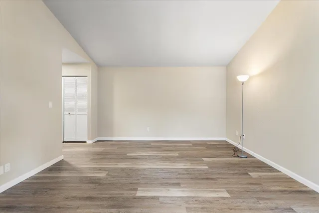 a view of an empty room with wooden floor