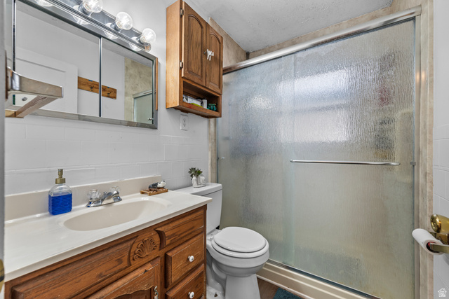 31 B Street Springville, UT 84663 - Photo 16 of 31 Bathroom featuring a wood-finish vanity with an integrated sink, a mirrored medicine cabinet with vanity lighting, and a shower with a frosted glass enclosure