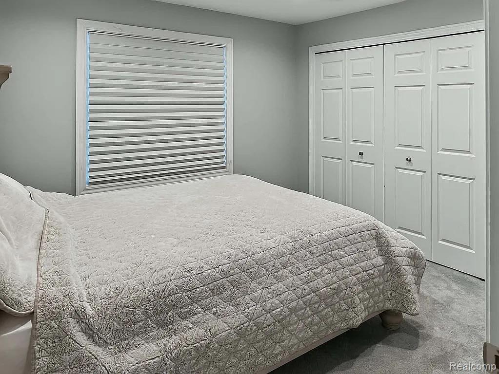 1555 Thompson Road Bad Axe, MI 48413 - Photo 8 of 14 Window with white trim, pleated blinds, and paneled bi-fold closet doors