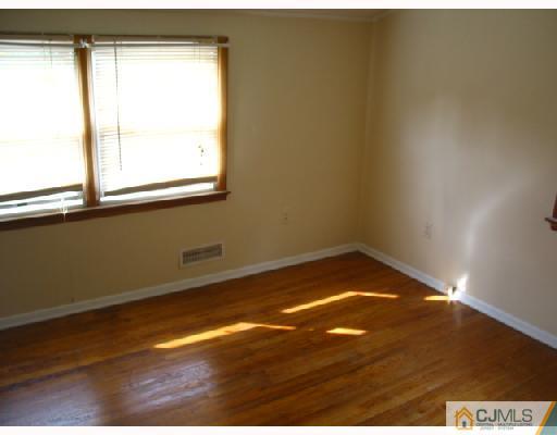 24 Stockton Road New Brunswick, NJ 08901 - Photo 4 of 10 a view of empty room with wooden floor and fan