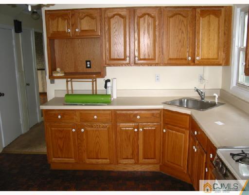 24 Stockton Road New Brunswick, NJ 08901 - Photo 6 of 10 a kitchen with granite countertop a refrigerator a sink and wooden cabinets