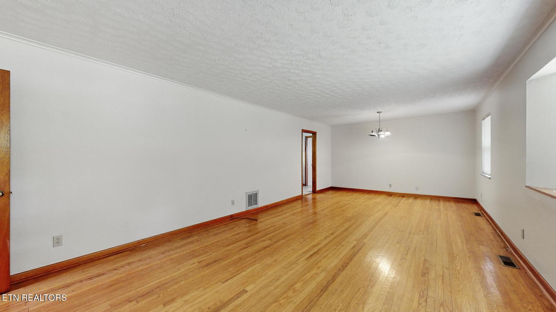 4004 Deerfield Road Knoxville, TN 37921 - Photo 4 of 34 a view of an empty room with wooden floor