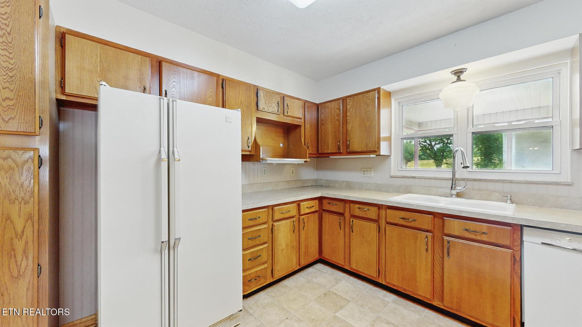 4004 Deerfield Road Knoxville, TN 37921 - Photo 7 of 34 a kitchen with a sink a refrigerator and window