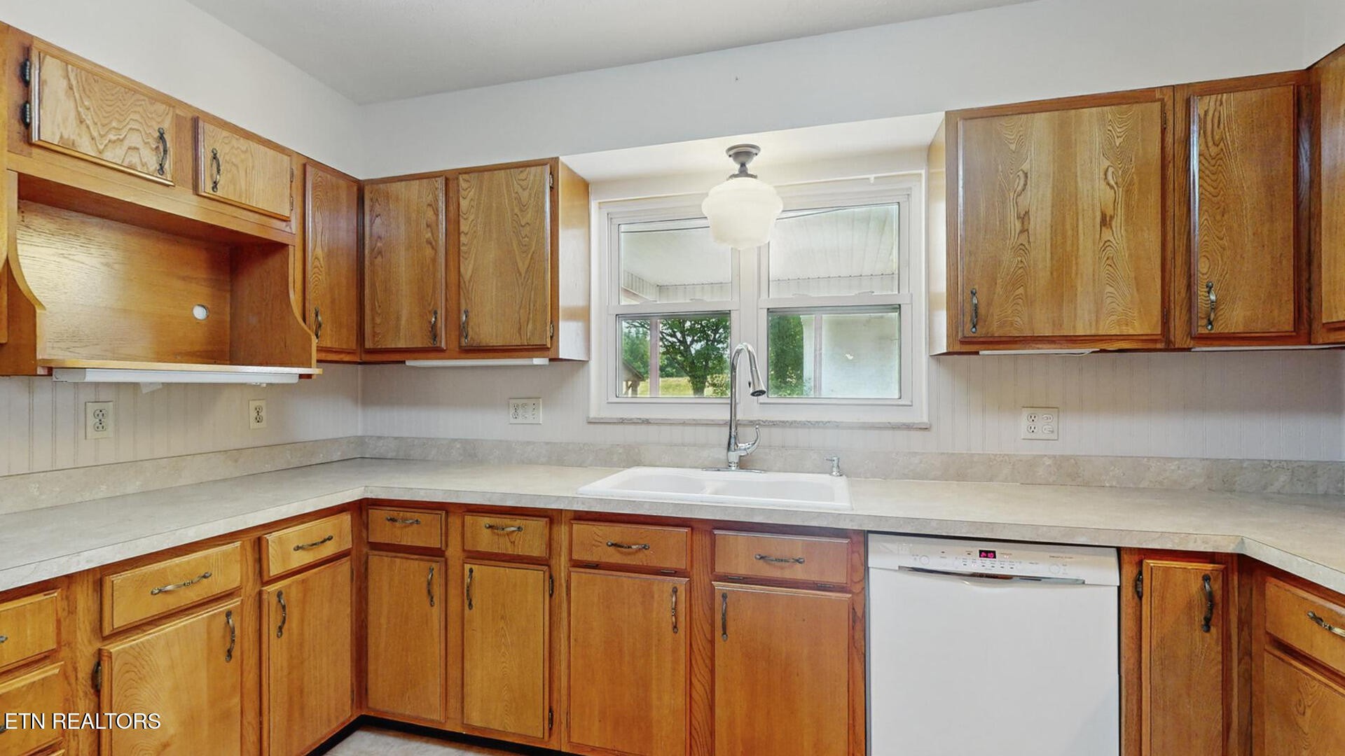 4004 Deerfield Road Knoxville, TN 37921 - Photo 9 of 34 a kitchen with stainless steel appliances granite countertop wooden cabinets a sink and a window