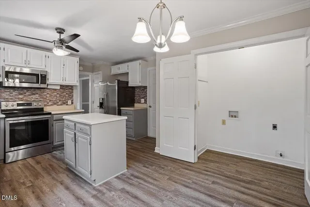 a kitchen with kitchen island granite countertop a sink appliances cabinets and a counter top space