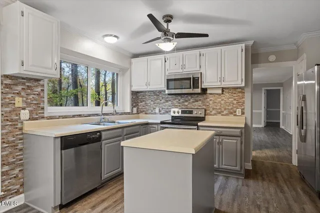 a view of an empty room with wooden floor fireplace and a window