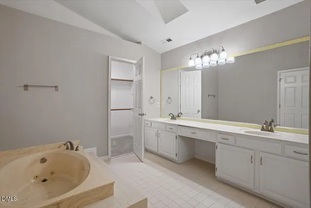 a spacious bathroom with a shower sink and mirror