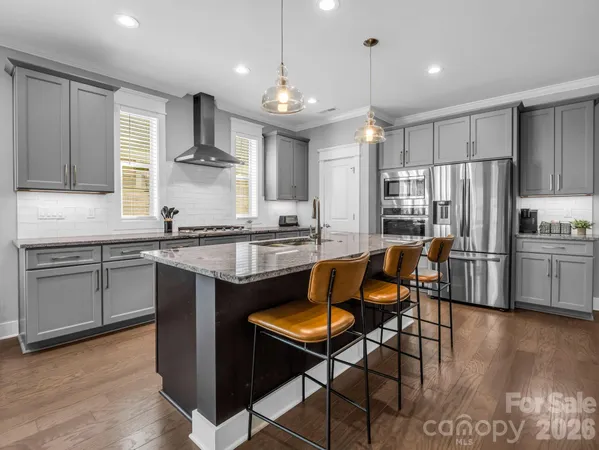a kitchen with granite countertop stainless steel appliances a sink window and cabinets