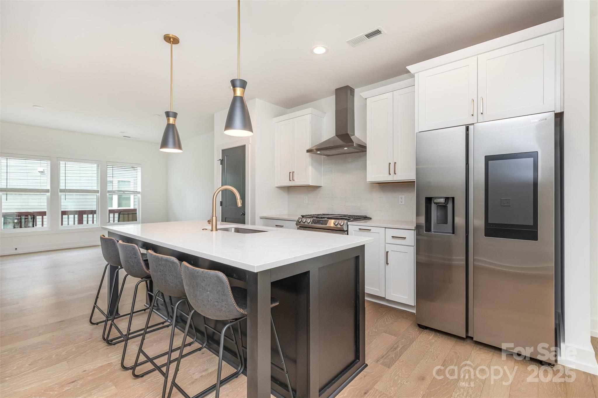 1500 Effingham Road Charlotte, NC 28208 - Photo 11 of 32 a kitchen with stainless steel appliances a table chairs in it and wooden floors