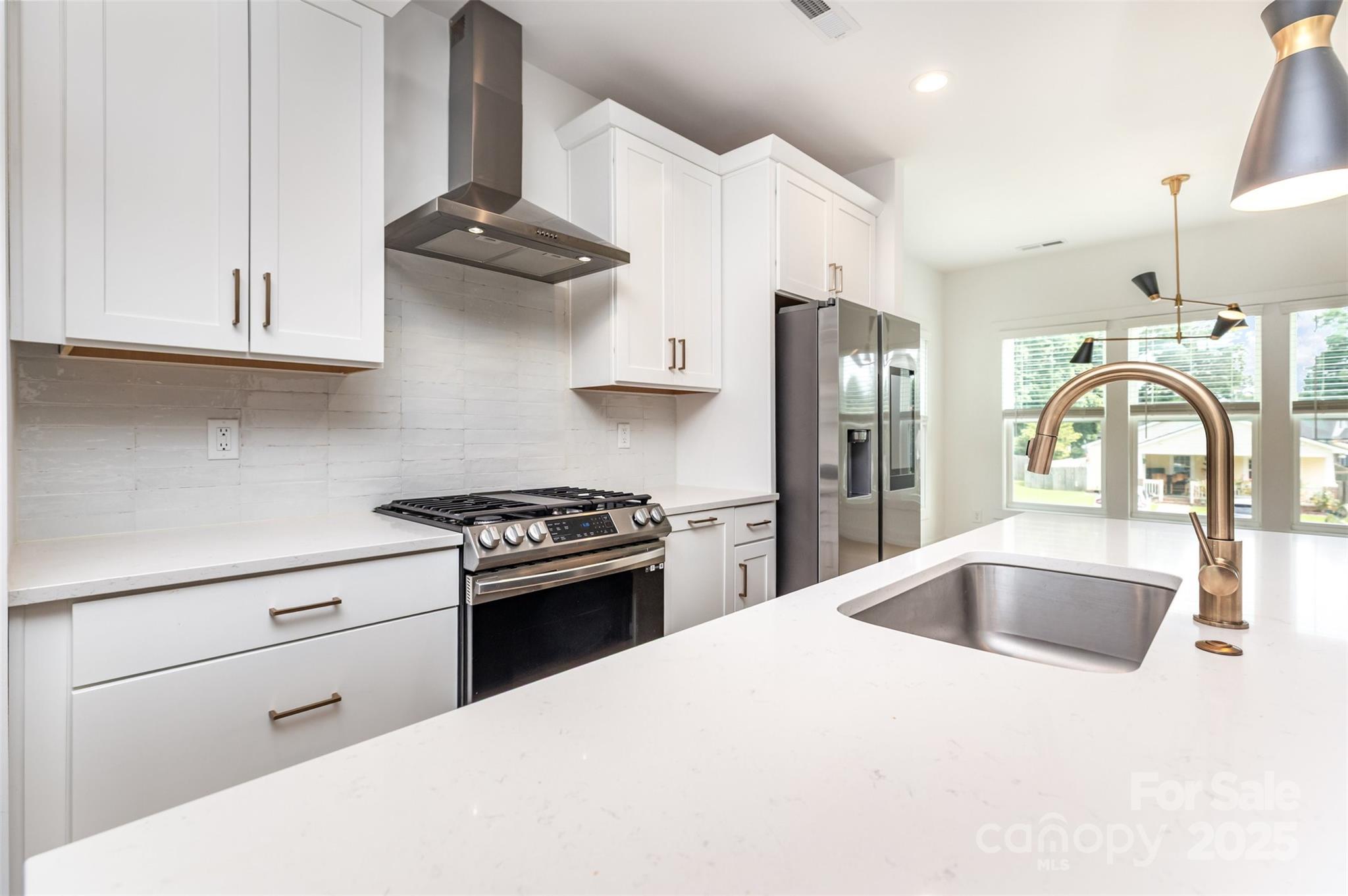 1500 Effingham Road Charlotte, NC 28208 - Photo 12 of 32 a kitchen with stainless steel appliances granite countertop a sink stove and refrigerator