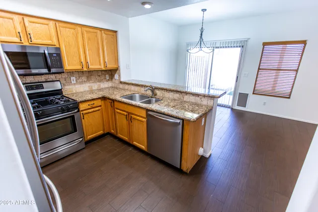 a kitchen with stainless steel appliances granite countertop a stove a sink and a microwave