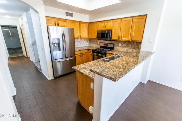 a kitchen with a refrigerator a stove top oven a sink and dishwasher