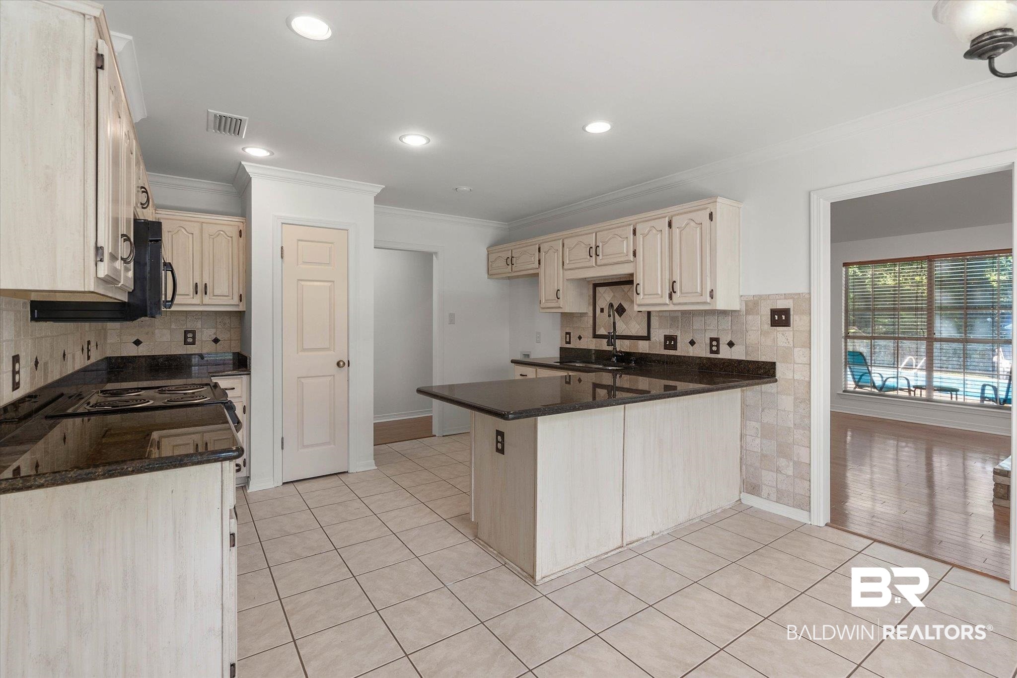 3032 Autumn Ridge Drive West Mobile, AL 36695 - Photo 5 of 20 Kitchen with a peninsula, light tile patterned floors, ornamental molding, tasteful backsplash, and recessed lighting