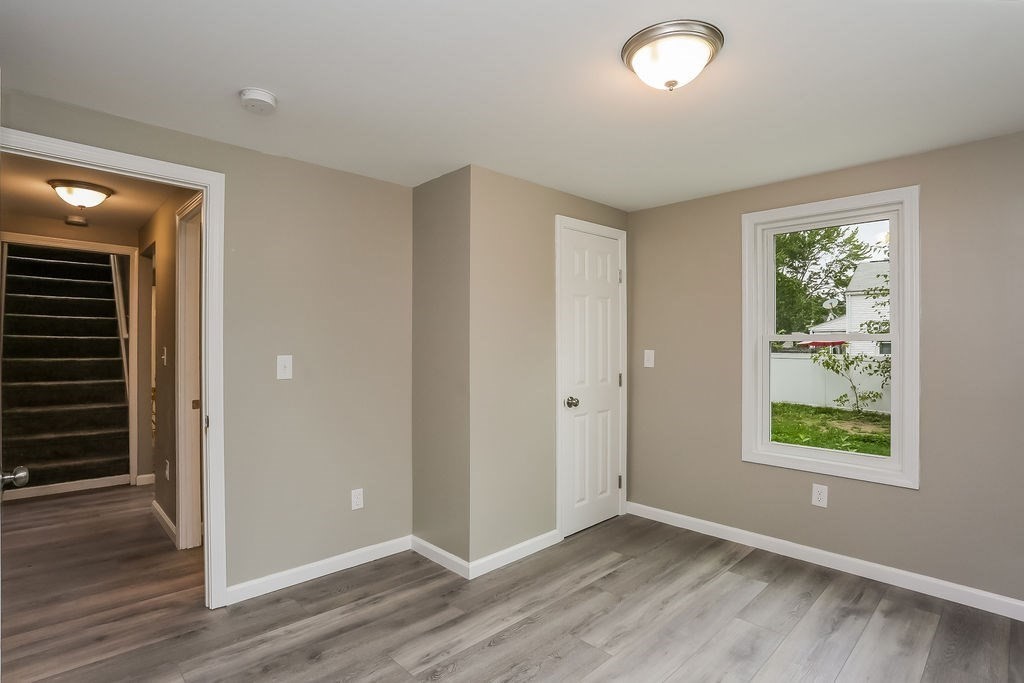 251 Edendale Street Springfield, MA 01104 - Photo 15 of 22 an empty room with wooden floor and windows