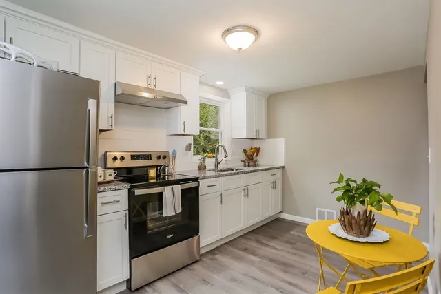a kitchen with a sink and white cabinets