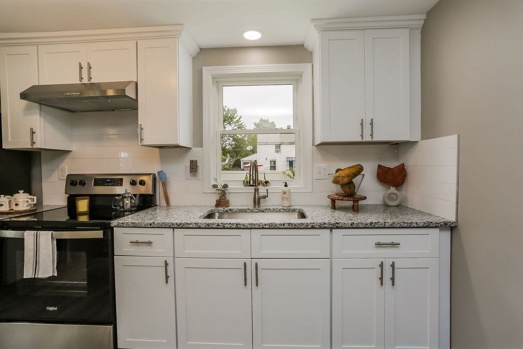 251 Edendale Street Springfield, MA 01104 - Photo 9 of 22 a kitchen with stainless steel appliances granite countertop a sink a stove and cabinets