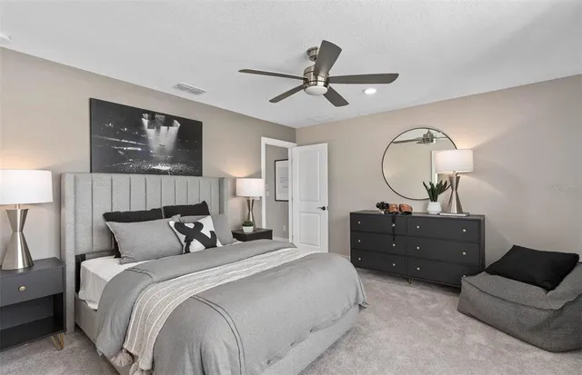 a bedroom with bed mirror and window