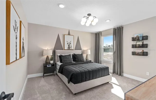 a bedroom with a large bed and a chandelier