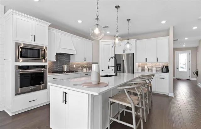 a kitchen with stainless steel appliances kitchen island a refrigerator sink and microwave