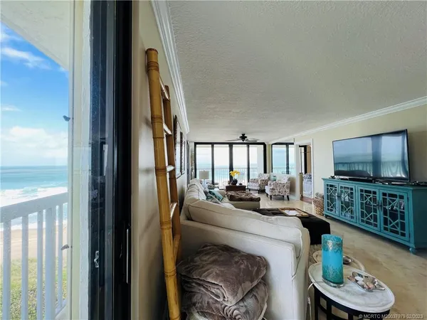 a living room with furniture and floor to ceiling windows