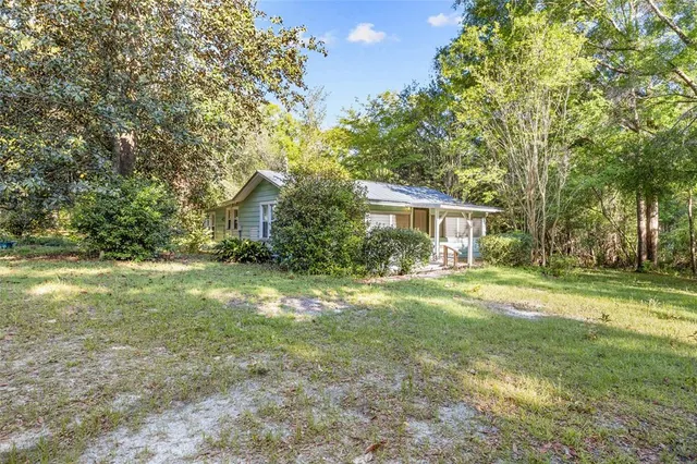 a view of a house with backyard and a tree