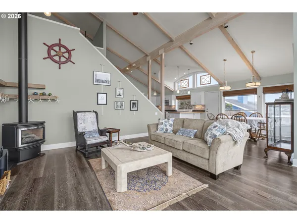a living room with furniture large window and wooden floor