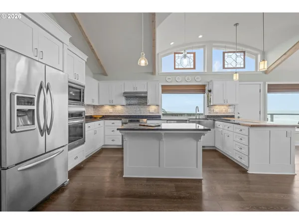 a kitchen with kitchen island white cabinets and stainless steel appliances