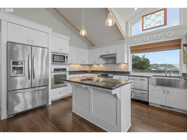 a kitchen with stainless steel appliances a refrigerator sink and microwave