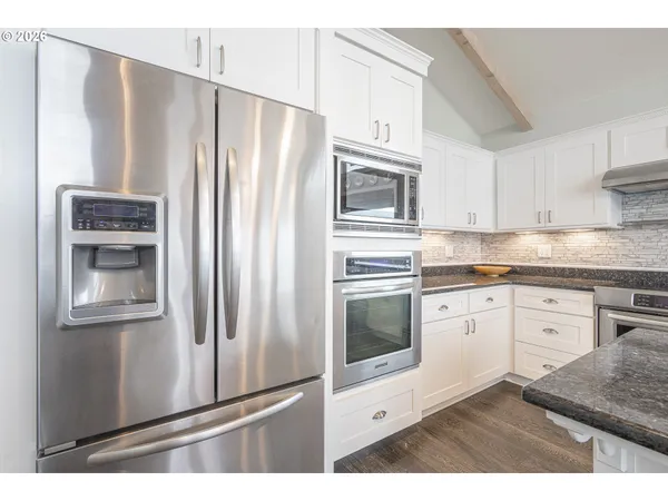 a kitchen with stainless steel appliances granite countertop a sink a stove and cabinets