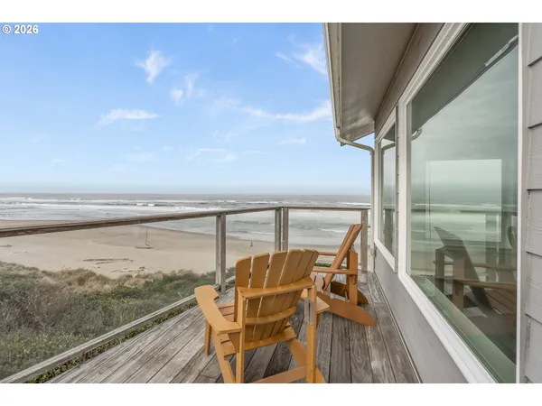 a balcony with wooden floor next to a yard