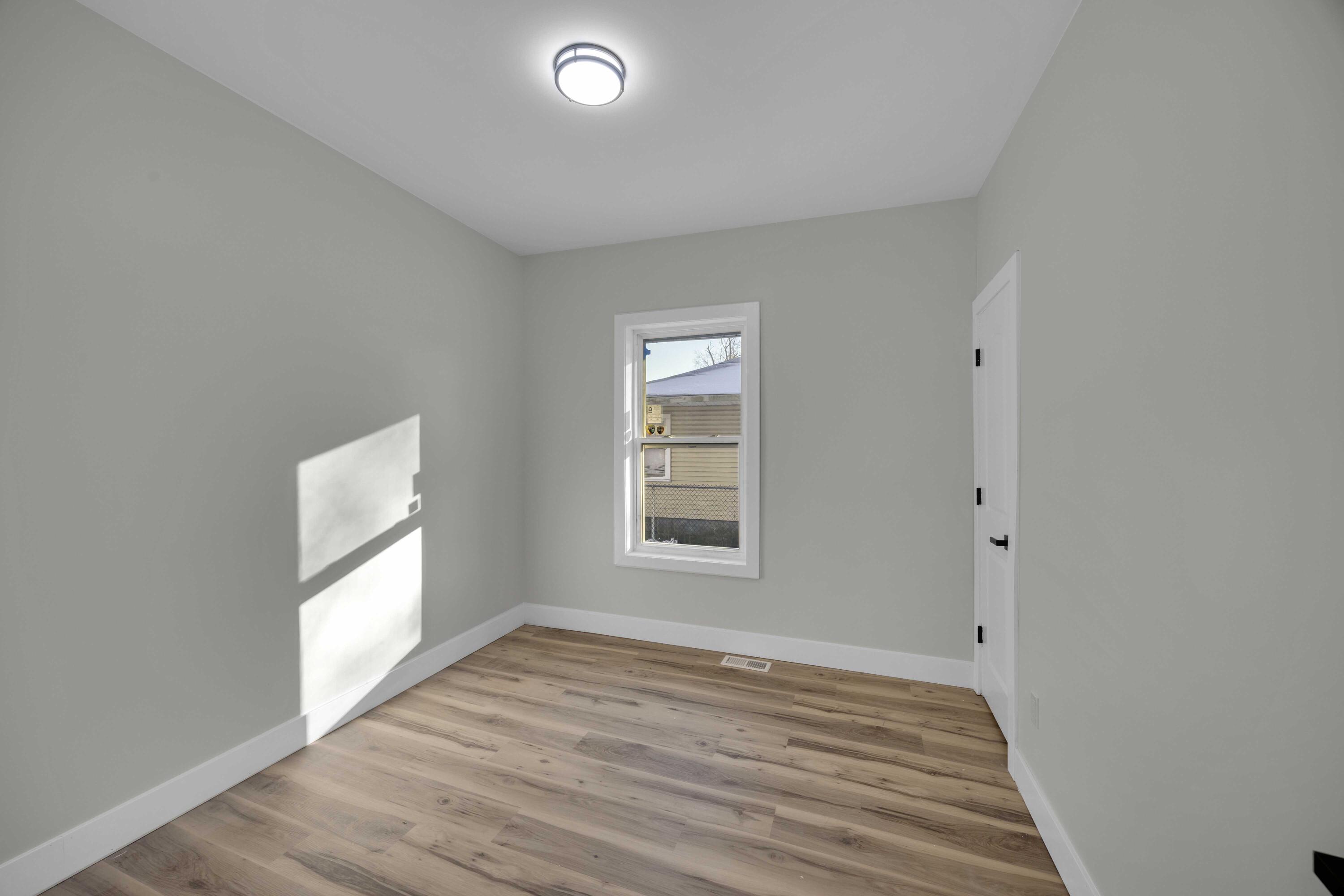 4200 Monroe Street Gary, IN 46408 - Photo 14 of 25 an empty room with wooden floor and windows
