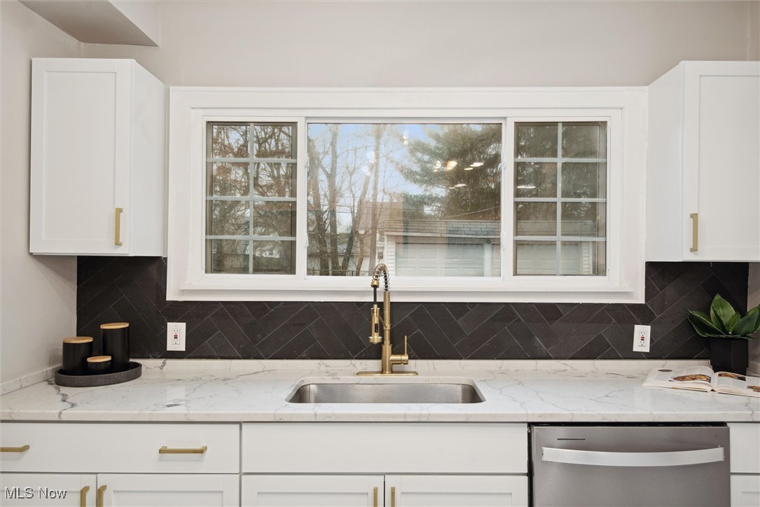 2444 Eaton Road Cleveland, OH 44118 - Photo 4 of 41 Kitchen with white cabinets, stainless steel dishwasher, light stone countertops, and sink
