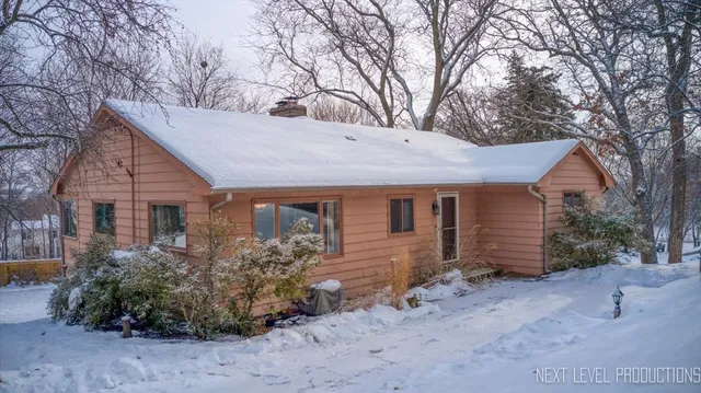 a view of a house with a yard and large tree