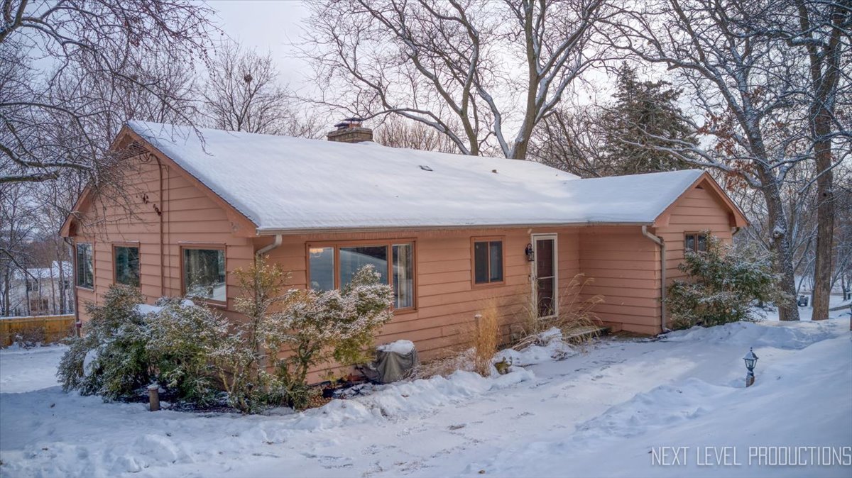 a view of a house with a yard and large tree