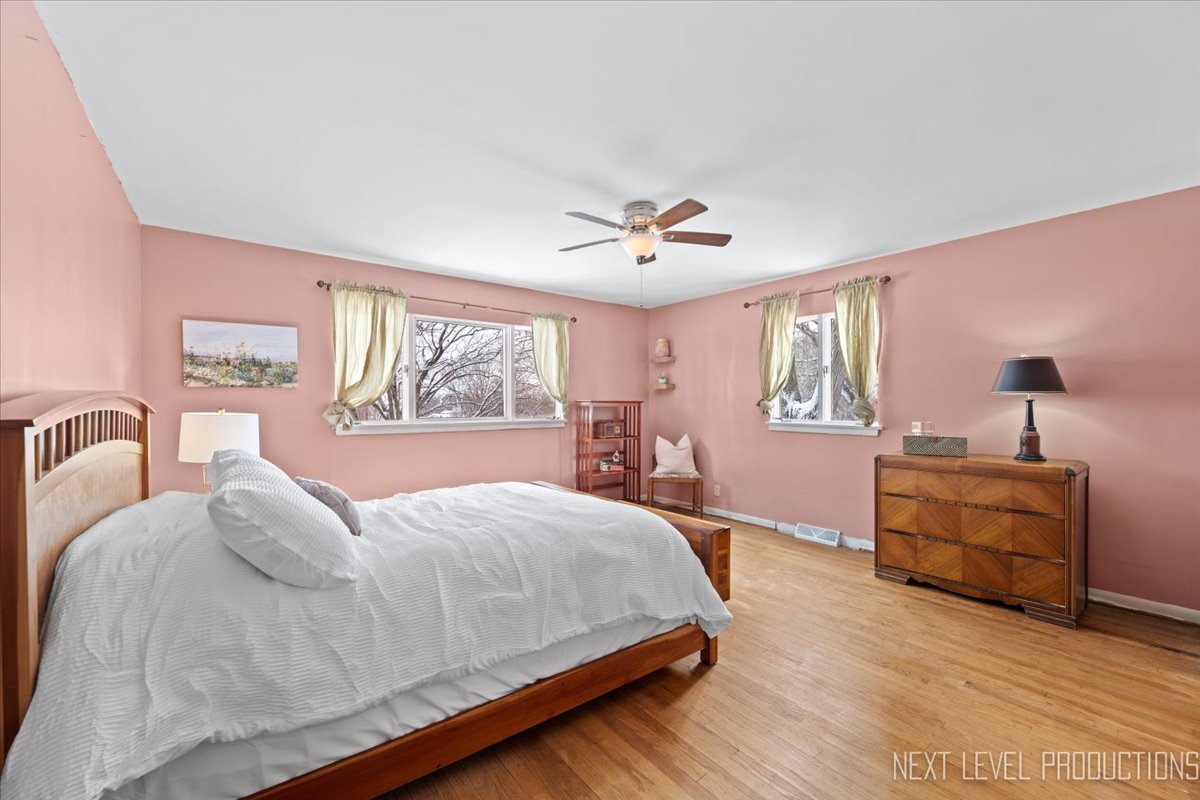 38W443 Sunset Drive St. Charles, IL 60175 - Photo 15 of 33 a bedroom with a large bed and wooden floor