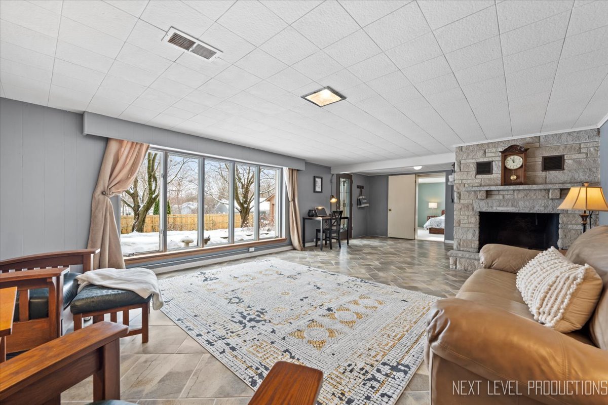38W443 Sunset Drive St. Charles, IL 60175 - Photo 22 of 33 a living room with furniture a large window and a fireplace