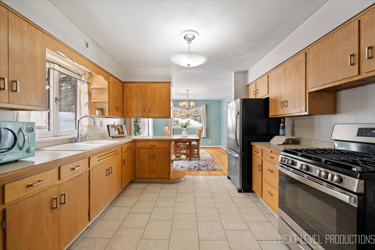 38W443 Sunset Drive St. Charles, IL 60175 - Photo 5 of 33 a kitchen with stainless steel appliances granite countertop a stove refrigerator sink and cabinets