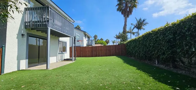 a view of backyard with potted plants and wooden fence