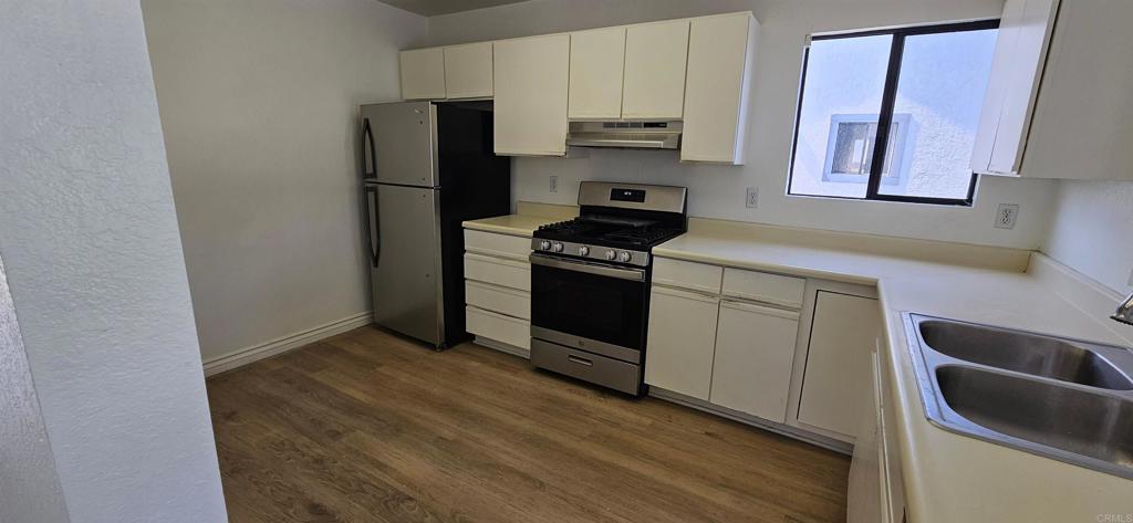658-660 Santa Fe Drive Encinitas, CA 92024 - Photo 8 of 14 a kitchen with wooden cabinets and stainless steel appliances