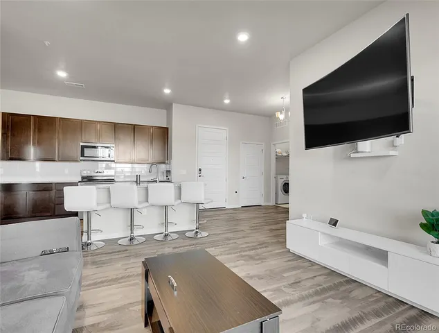 a large kitchen with stainless steel appliances kitchen island a large counter top a stove and a sink