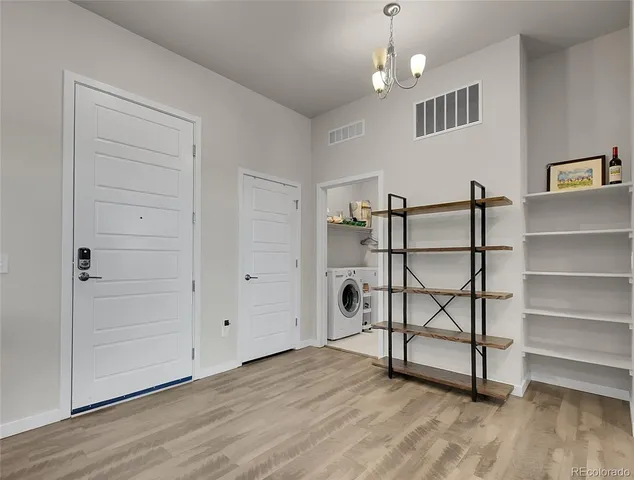 an empty room with wooden floor cabinet and windows