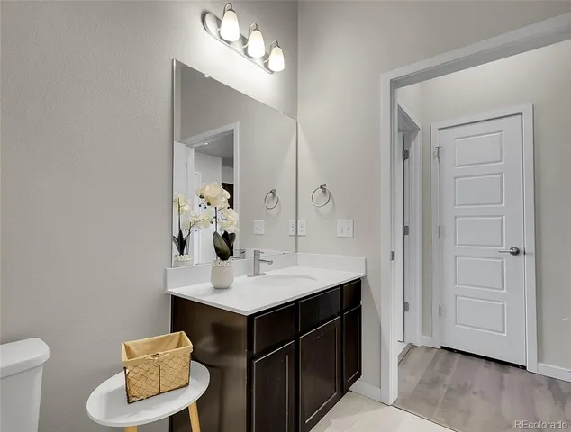 a bathroom with a sink vanity and a toilet