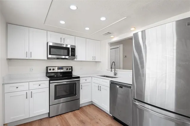 a kitchen with stainless steel appliances a refrigerator sink and microwave