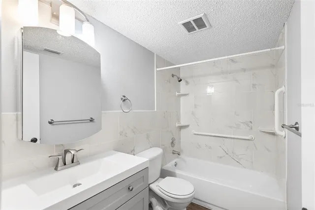 a bathroom with a bathtub shower sink vanity and toilet