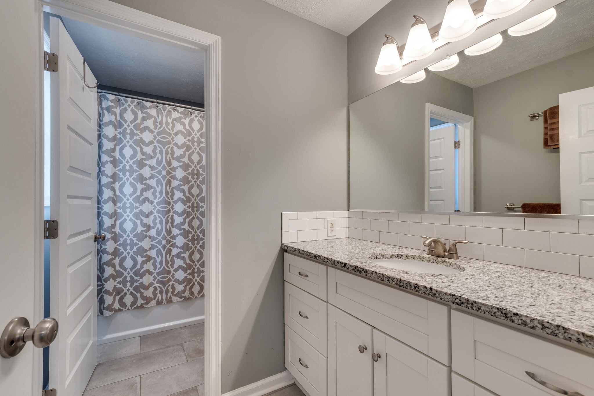 7593 Beech Hill Road Pulaski, TN 38478 - Photo 20 of 40 a bathroom with a granite countertop sink a mirror and a shower