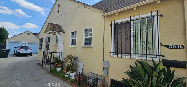 a view of a house with a small yard and potted plants