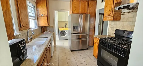 a kitchen with a stove a refrigerator and a sink